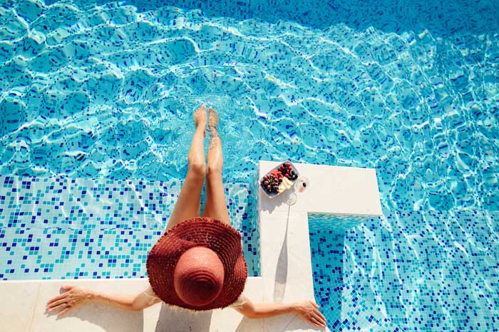 woman relaxing robotic pool cleaner