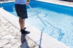 man cleaning pool